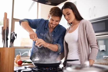 A man and a woman happily cooking together